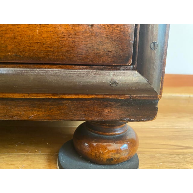 A Theodore Alexander Campaign-style Acacia solid brass finish. The chest or filing cabinet has a 9-drawer chest of drawers...