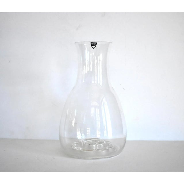 A vintage, Swedish Orrefors glass crystal decanter or water carafe with a flower design at the base in the Nils Landberg...