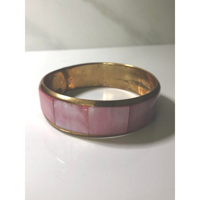 This feminine vintage pink mother-of-pearl and gold bangle will be a nice addition to your jewelry collection. The pink...