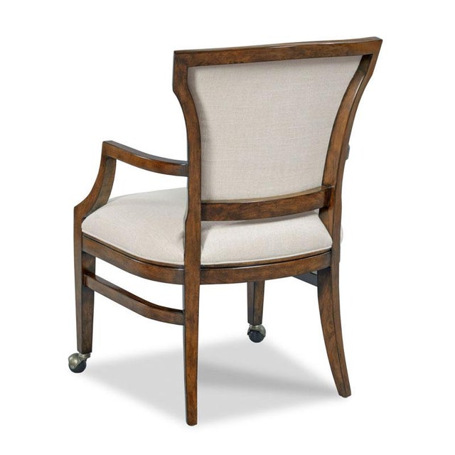 An upholstered back rests above an upholstered seat raised by tapering legs fitted on the front with sturdy casters.