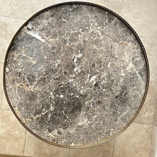 Beautiful Louis XVI round wooden marble top “buoillotte” game or coffee table with brass edges. An early 20th century...