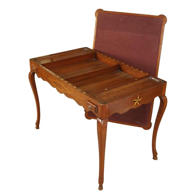 A charming wooden games table featuring a parquetry chessboard top that opens to reveal a felt-lined playing surface. The...