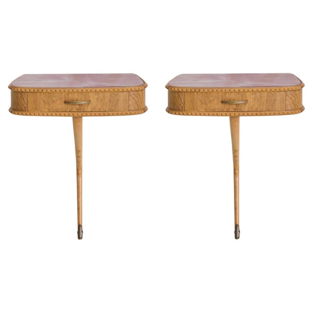A wall-mounted Italian nightstand from the 1950s, defined by its sculptural profile and original pink glass top with...