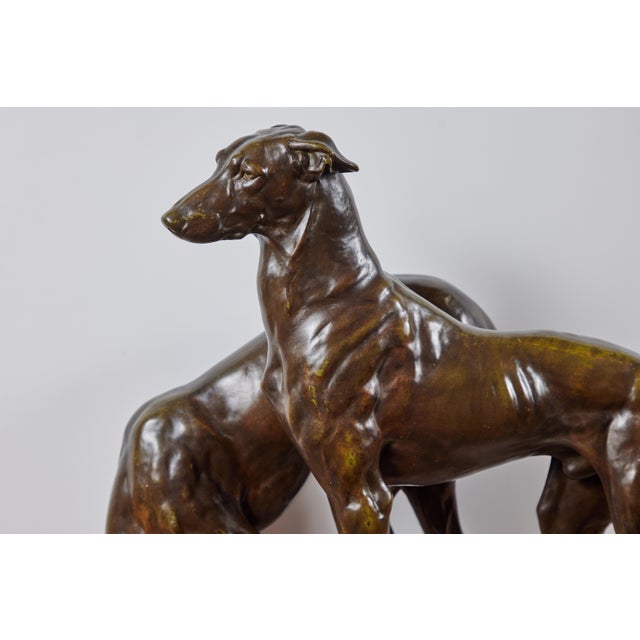 An elegant pair of 1920's, patinated, bronze hounds initially conceived and created by master sculptor, J.E. Masson...