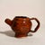 A beautifully expressive piece of handmade studio pottery featuring a rich, high-gloss red glaze with organic black...