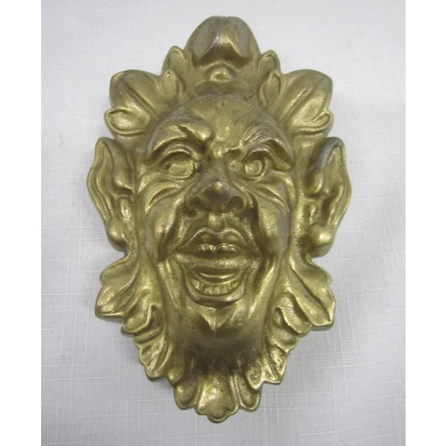 Heavy cast brass door knocker. Bacchus face with back plate. It measures 6"H x 4"W x 2.5"D. The mounting plate measures...