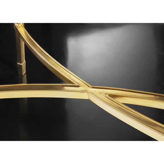 Crafted with a polished brass frame, its sleek structure exudes luxury, while the tempered clear glass top provides a...