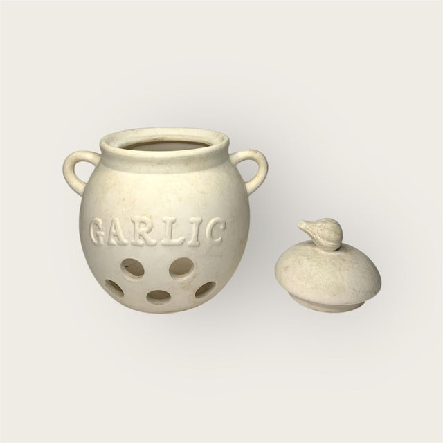 Practically magical, a vintage ceramic garlic keeper from Cook's Club, a novelty kitchenware brand active in the 1970s....