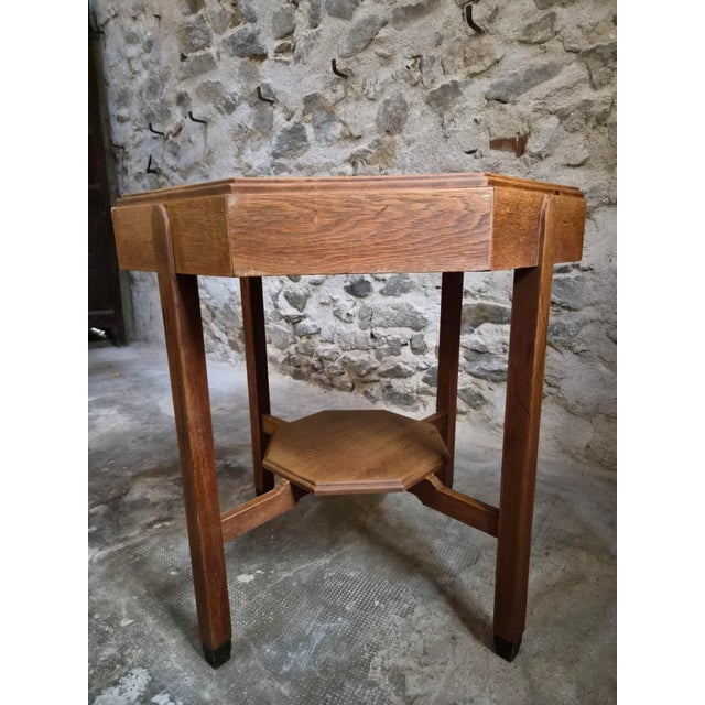 A Dutch oak side table dating from around 1925–1935, designed in the Amsterdam School style. The table is made of solid...