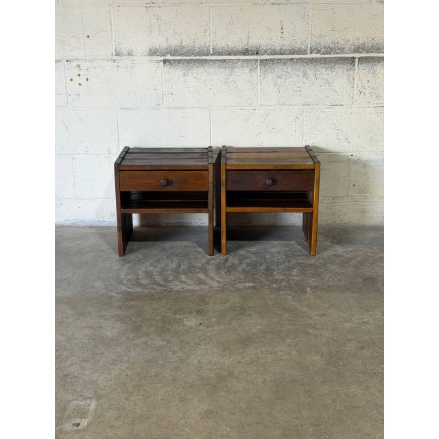 This pair of nightstands features a rustic plank construction with built-in storage drawers and lower shelves. The boxy...