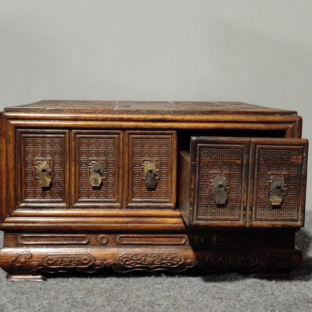 A striking vintage Chinese five-drawer jewelry chest or desktop cabinet, crafted from heavy, deeply grained wood in the...