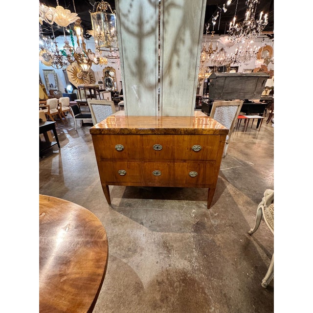 The 19th century German Biedermeier Walnut Commode is an antique piece of furniture that exudes elegance and...
