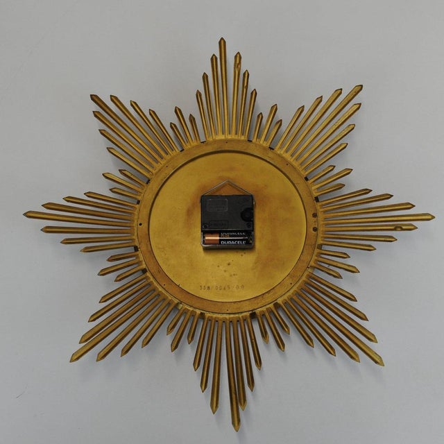 A vintage brass ato mat sunburst wall clock by junghans. This piece is attributed to the mentioned designer/maker. It has...