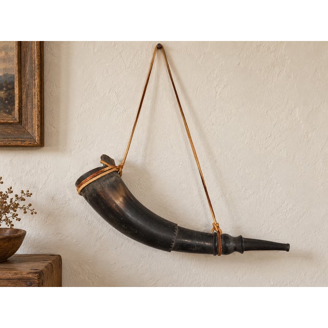 A striking vintage Colonial-style powder horn featuring a naturally curved dark bovine-horn body, turned wood pouring...