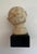 Small bust of baby’s head on wooden block