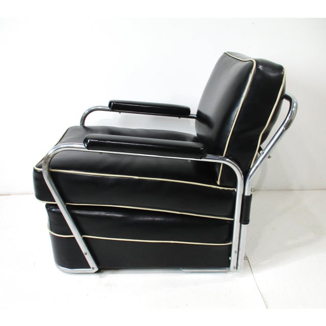 A superb quality Art Deco chrome framed streamline lounge chair with black leatherette upholstery having off white piping...