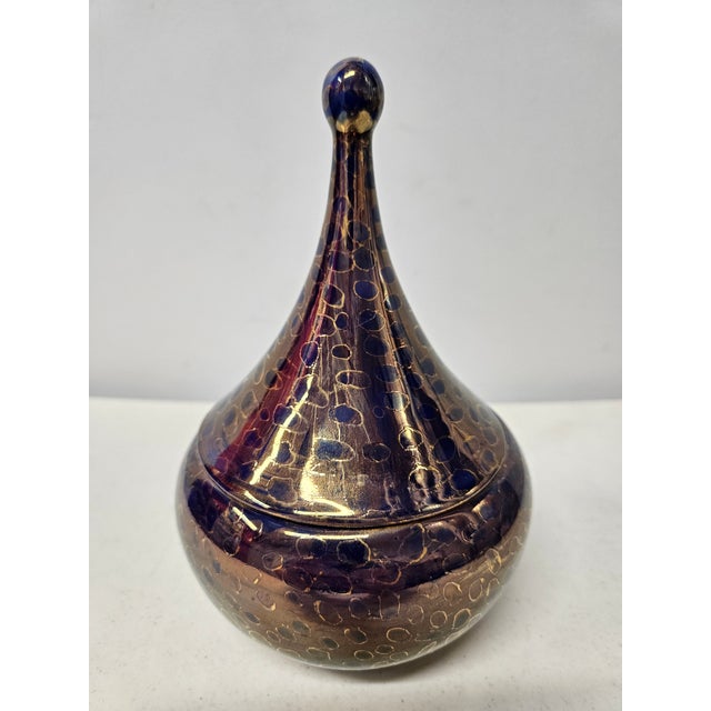 A vintage lidded teardrop-shaped porcelain bowl or box in the style of pieces by Rosenthal. This piece is purple and gold...