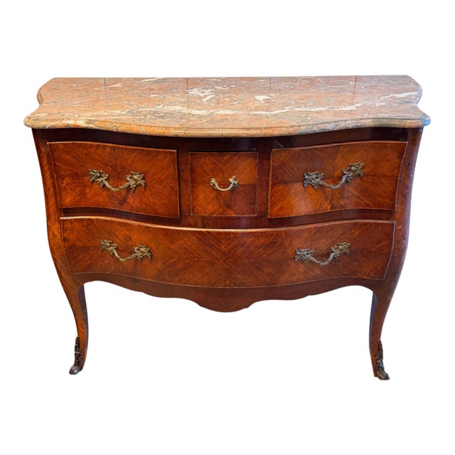 A French marble top commode with a shaped marble top over a serpentine case fitted with two long drawers and three smaller...