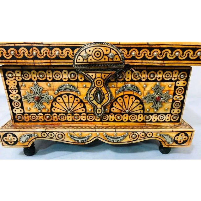 A decorative orange resin and black tribal design chest or jewelry box. The chest interior is leather and features...