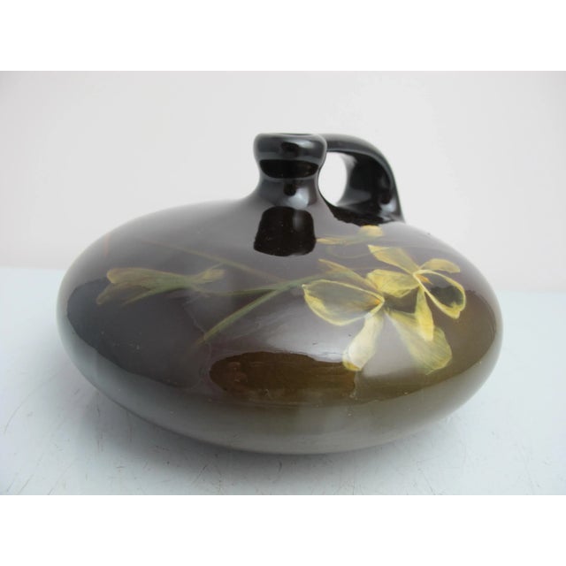 Antique Louwelsa Weller pottery vase. Tones of brown with taupe and umber flowers. Disc shape just style with short neck...