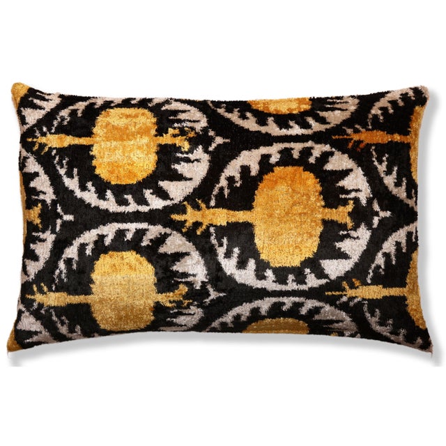 "This luxury silk velvet ikat lumbar pillow features a striking black ground accented with rich gold and soft ivory tones,...
