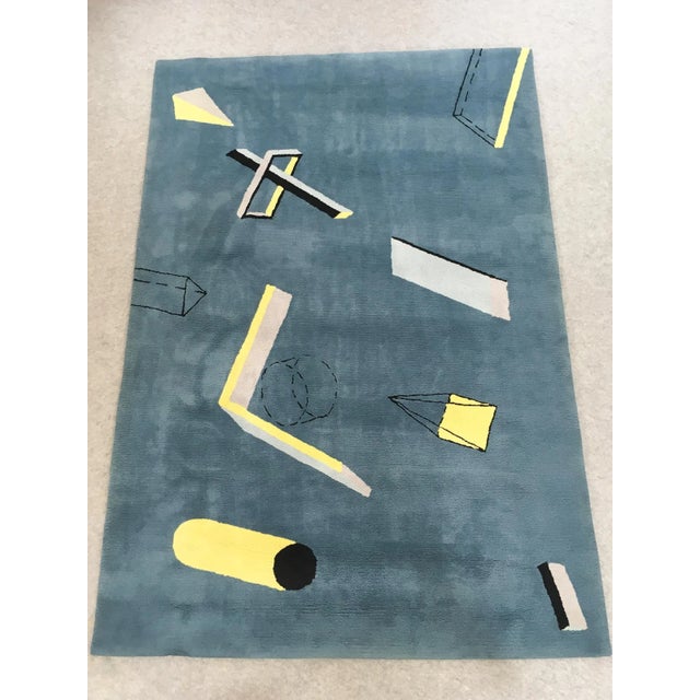 This rectangular rug, designed by Fritsch Design, features abstract geometric patterns in the Bauhaus/Postmodern style of...