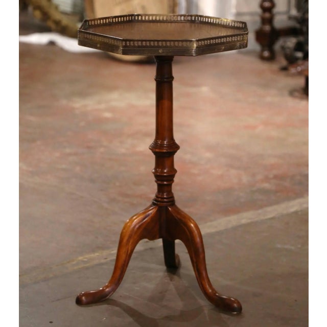 Decorate a den or living room with this elegant side table. Crafted in England circa 1990, the table stands on a carved...