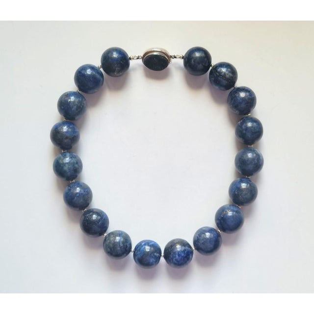 The length of the necklace is 17.5 inches (44.5 cm). The size of the smooth round beads is 21-22 mm. The lapis lazuli...
