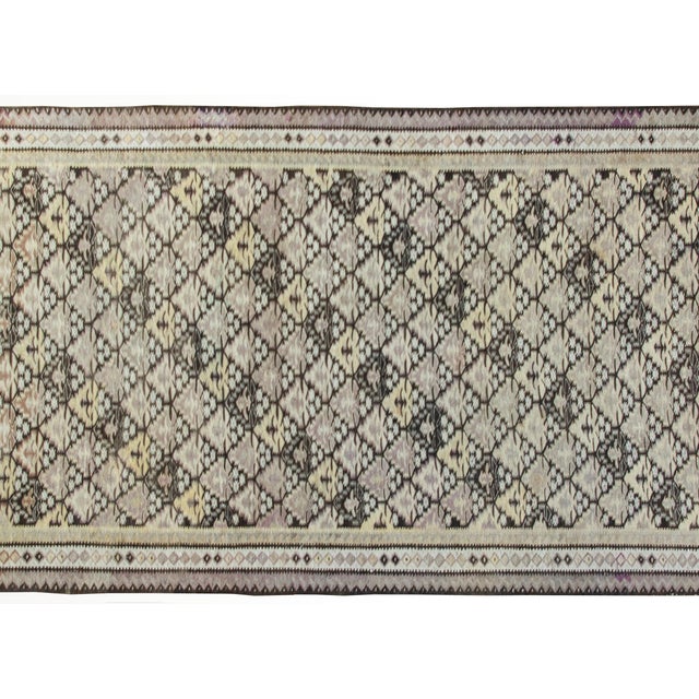 A beautiful early 20th century Persian Qazvin Kilim rug with a tree-of-life pattern woven in alternating colored stripes...