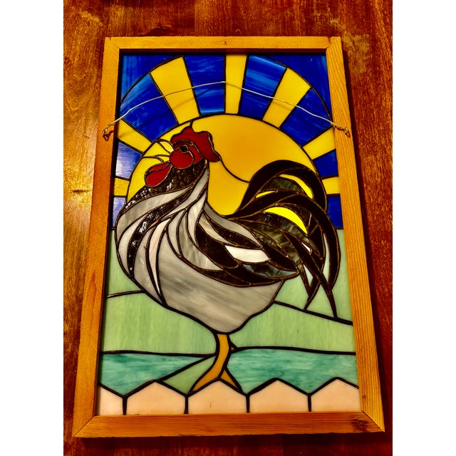 This is a captivating stained glass panel featuring a proud rooster crowing, depicated against a vibrant sunrise. Framed...