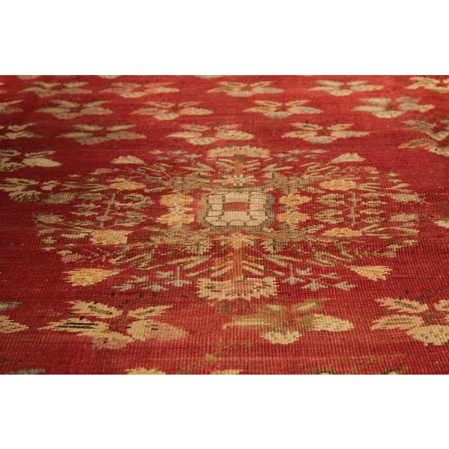 Hand knotted in wool originating from Turkey circa 1900-1910, this antique floral Gordes rug enjoys the marriage of an...