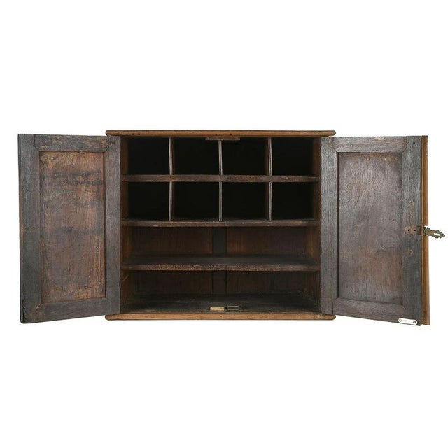 This antique piece of furniture, made entirely of solid wood, evokes the world of artists' studios and cabinets of...
