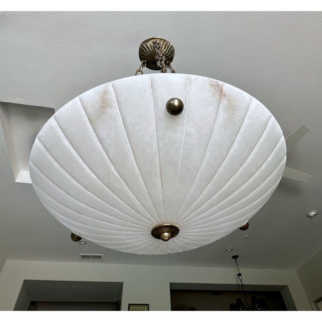 French alabaster pendant light with brass aged (antiqued finish) fittings in the Directoire style. Interior lighting uses...