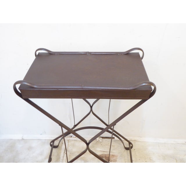 This iron small console table has a patinated finish.