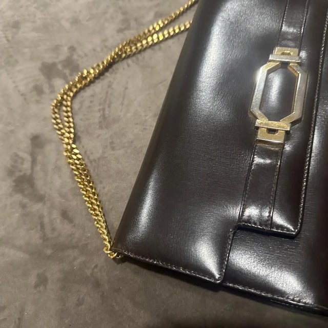 This vintage 1970s Italian clutch bag is a masterful example of the era's commitment to high-quality artisanal...