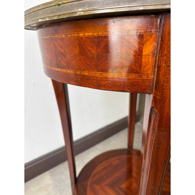 Late 18th/early 19th century round accent table with marquetry and marble top. Gilt bronze sabots and encircling the top...