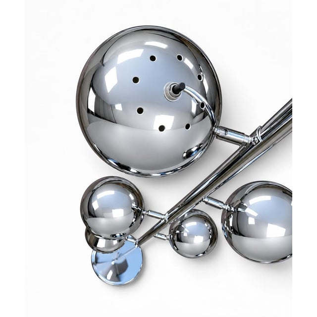 A sculptural space-age floor lamp from the 1960s-70s American eyeball tradition. Six polished chrome globes are staggered...