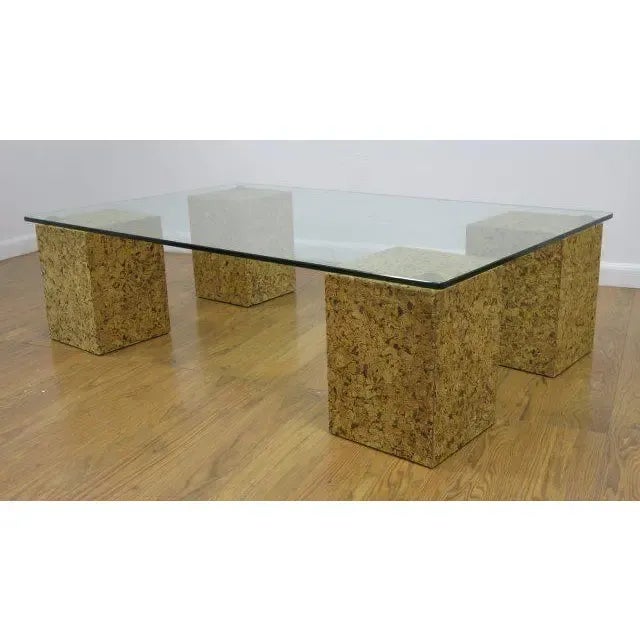 Fantastic 1970s coffee table with four block legs fabricated from cork with brass accent hardware and rectangular glass...