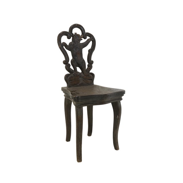 A classic late 19th-century Swiss Brienz "Black Forest" style carved bear chair. This antique wooden chair features a...