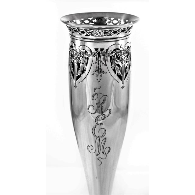This bud vase has a very feminine silhouette with a tapered bottom. Around the top there is a ring of lattice work around...