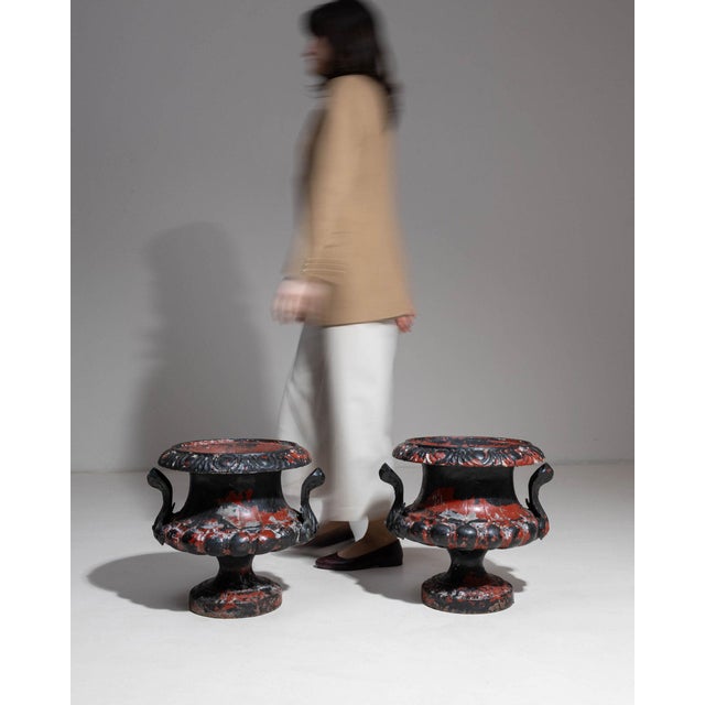 Here is a pair of urns, its black with red/oxblood painted floral motif, campana form the first thing to catch the eye....