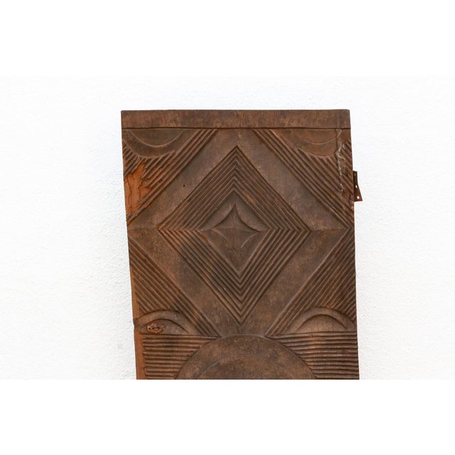 Carved from a single length of hardwood, this door continues Mali's Dogon and Bamana geometric tradition at a bolder,...