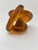 A striking signed amber and cognac art glass infinity knot sculpture, distinguished by its complex interlocking form and...