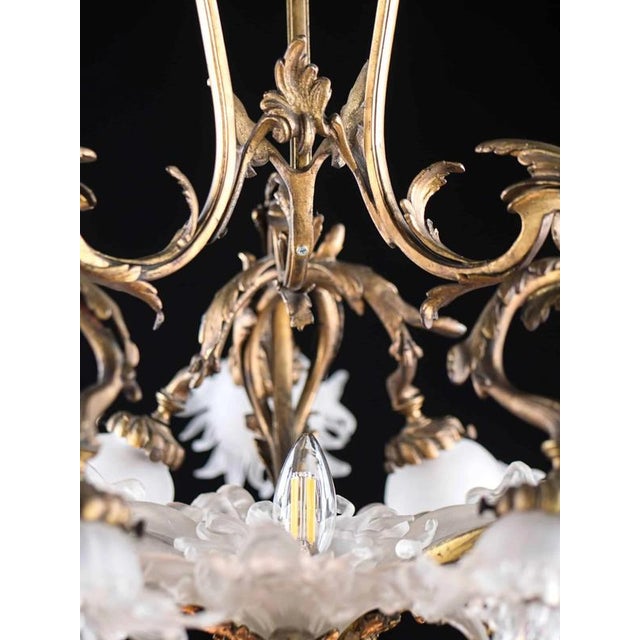 Amazing chandelier from the Art Nouveau period in top quality. Body made of patinated bronze. Glass floral shades. The...