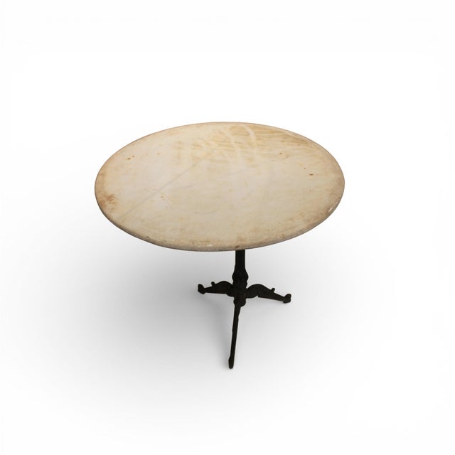 A distinguished 19th-century French antique table featuring a stone top set upon a finely crafted iron base. The table...