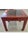 A classic Antique Chinese side table featuring a vibrant, hand-applied red painted finish and an inset dark slate stone...