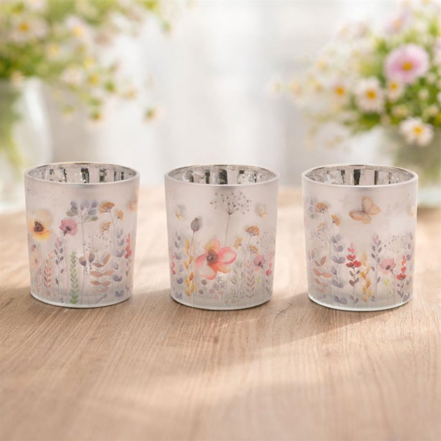 Bring warmth, light, and artistry into your home with this set of floral votive candle holders.These luminous matte silver...
