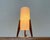 Small tripod table lamp from the 1960s. The diffuser is a simple cylinder made of a fiberglass-like material. It rests on...