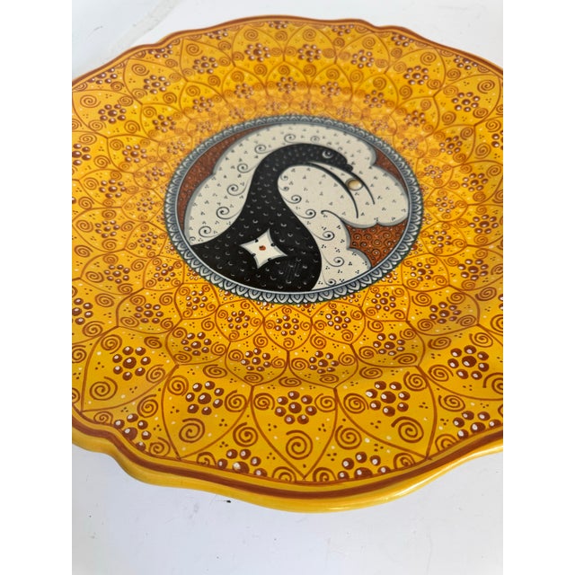 A striking hand-painted majolica plate that features a traditional stylized bird design crafted in the world-renowned...