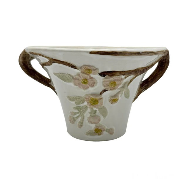 Beautiful vintage pottery piece. This flared white planter has textured wood like handles and embossed flower motif in...
